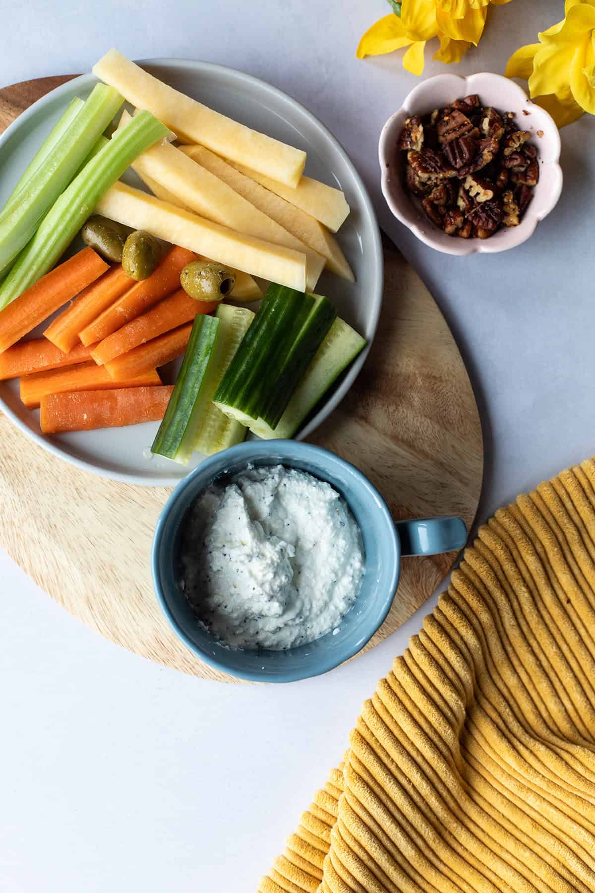 Blue mug with cottage cheese ranch dip with a tray of vegetables.
