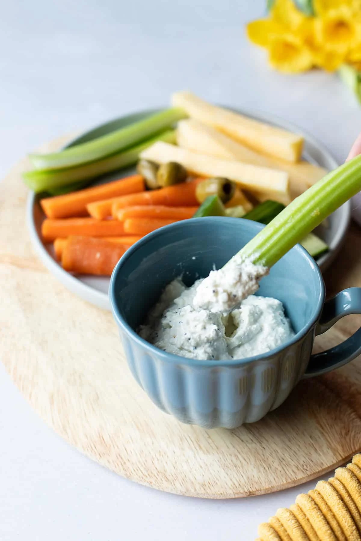 A celery stick in a cottage cheese ranch dip.