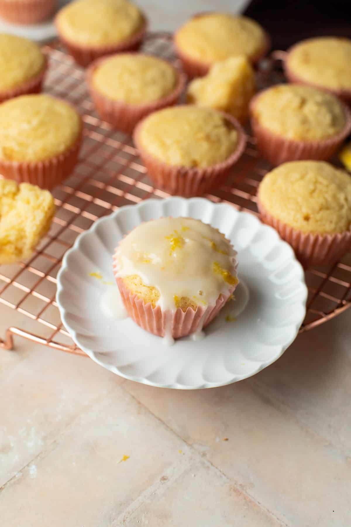 A lemon drizzle muffin on a white plate.