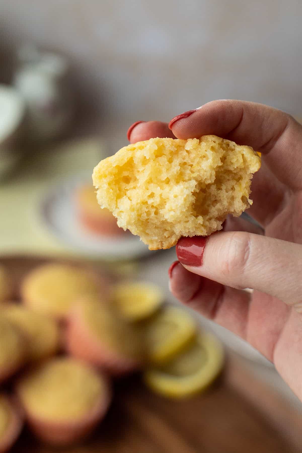 Hand holding a torn open muffin to show the fluffy insides.