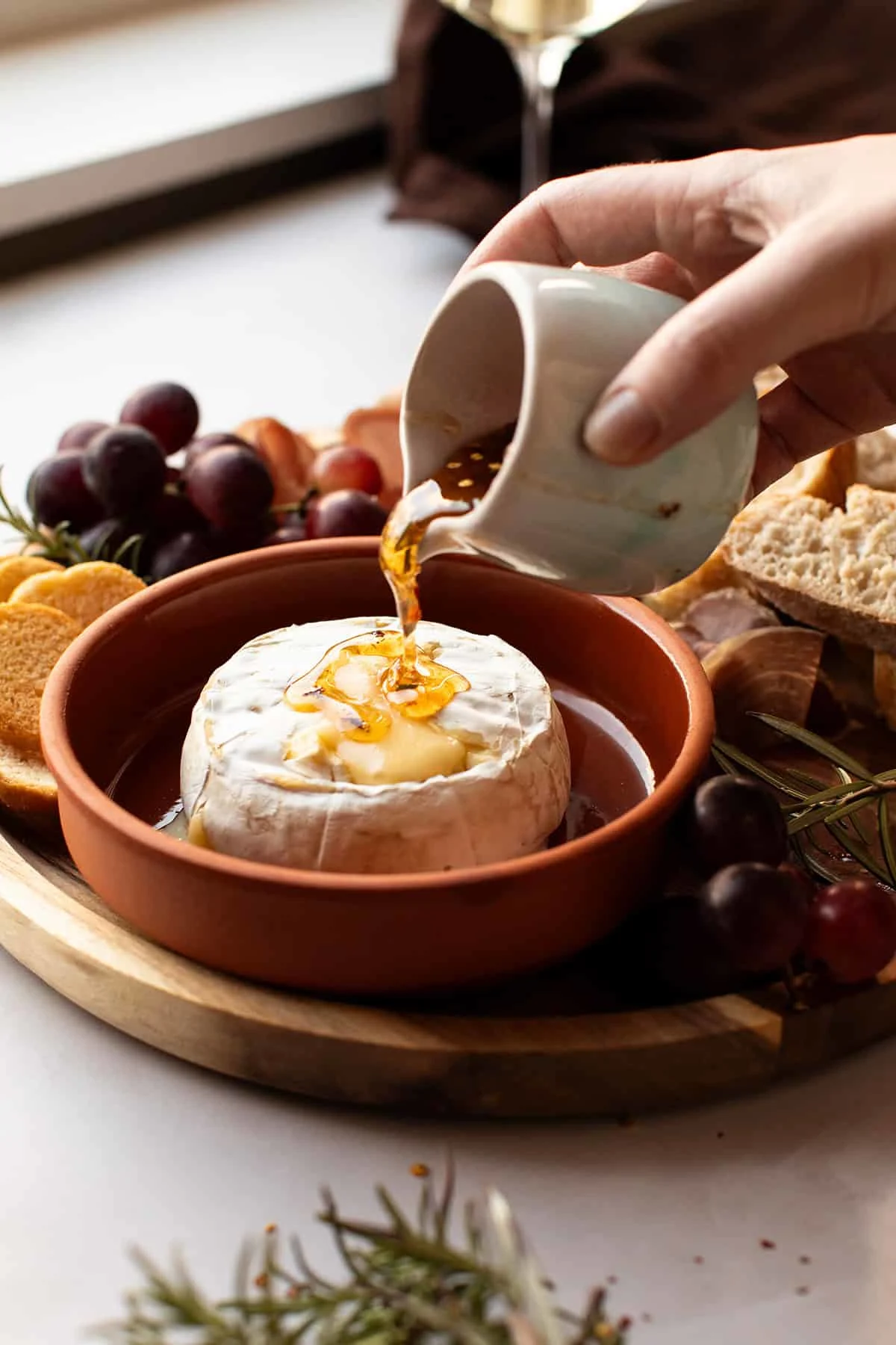 Pouring hot honey over the baked brie.