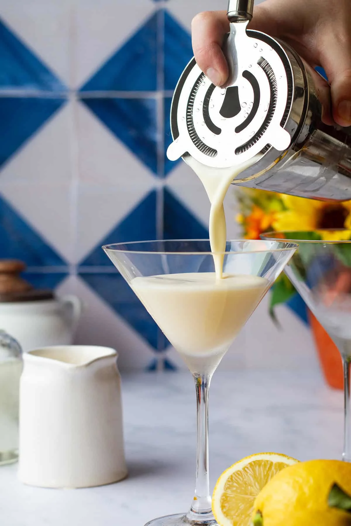 Pouring creamy martini in a martini glass.