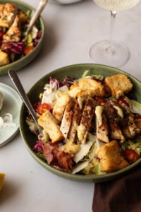 Close-up of a shallow bowl with chicken caesar salad.